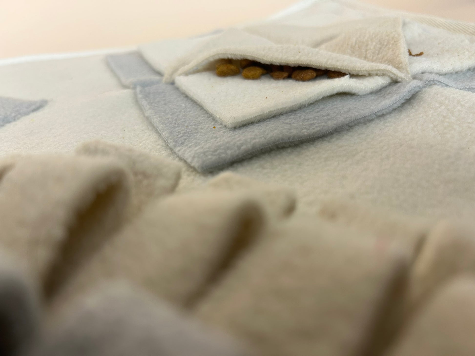 Close-up of The Nest Mat fleece folds showing texture and enrichment pockets